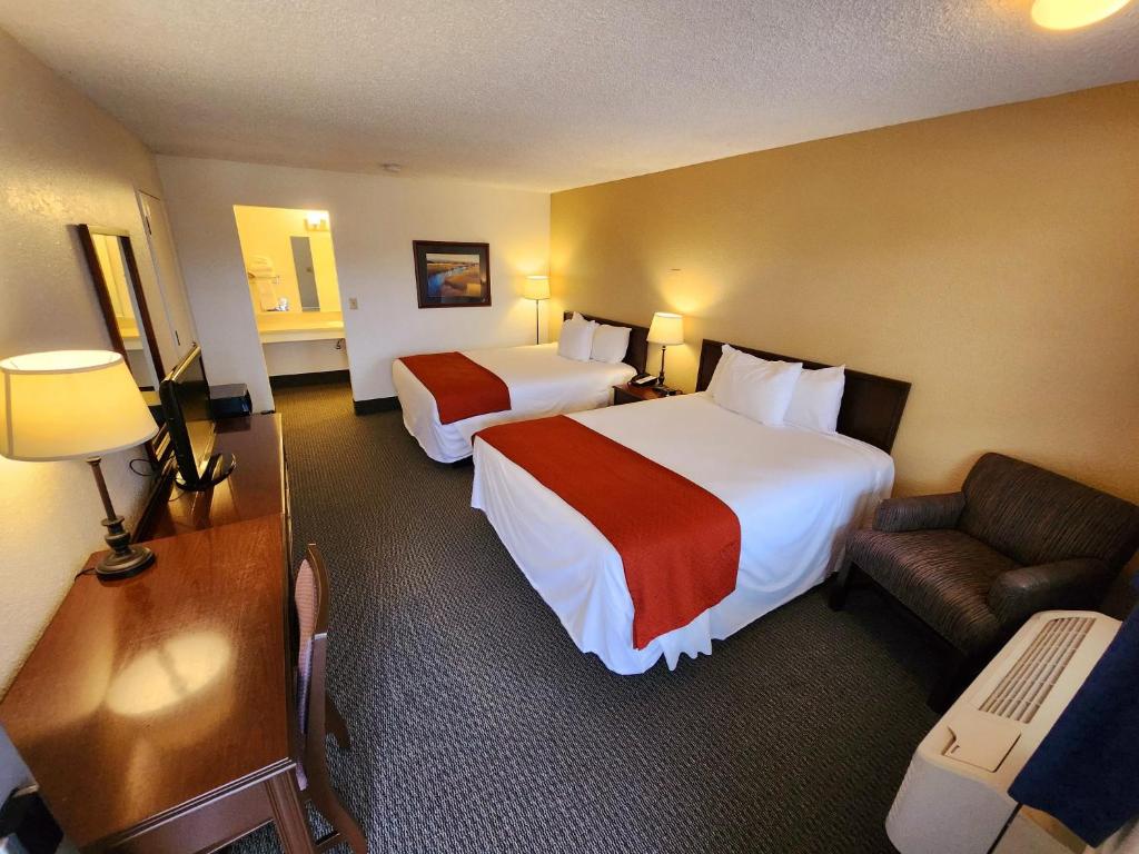 Habitación de hotel con 2 camas y sofá en Budget Motel en Burley