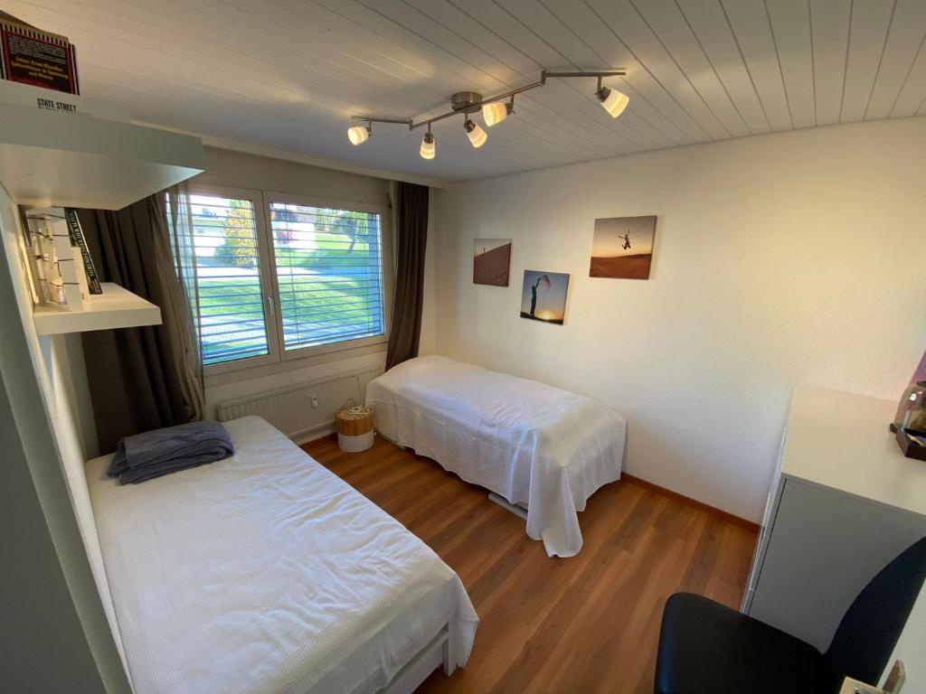 una camera da letto con due letti e una finestra di Apartment Arvenbüel-Flüügespitz ad Amden