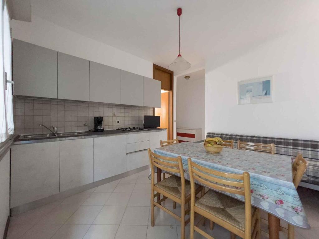 kuchnia ze stołem, krzesłami i blatem w obiekcie Apartments in Lignano 21774 w Lignano Sabbiadoro