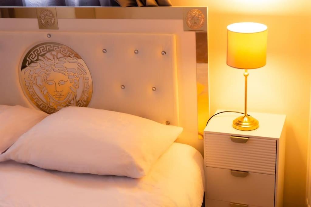 een slaapkamer met een bed met een lamp op een nachtkastje bij Belle maison Paris/Disney in Sucy-en-Brie