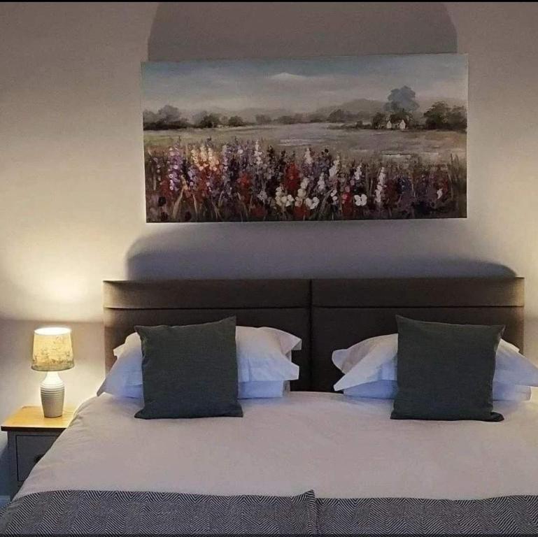 um quarto com uma cama com um quadro na parede em The Kenmuir Arms Hotel em New Luce