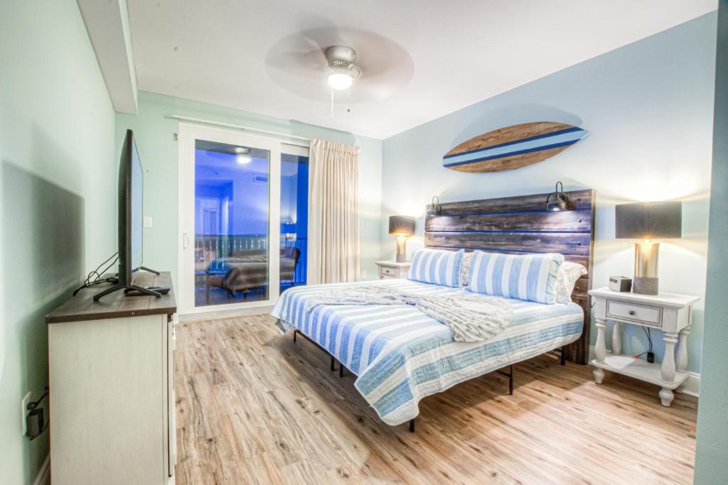 ein Schlafzimmer mit einem Bett und einem TV in der Unterkunft Laketown Wharf 1238 - Brand New End Unit With Wrap Around Balcony in Panama City Beach