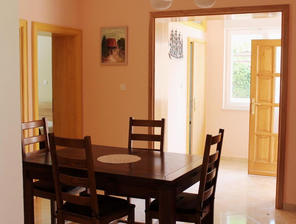 a dining room with a wooden table and chairs at Apartments Beautiful Sandy Beach in Split