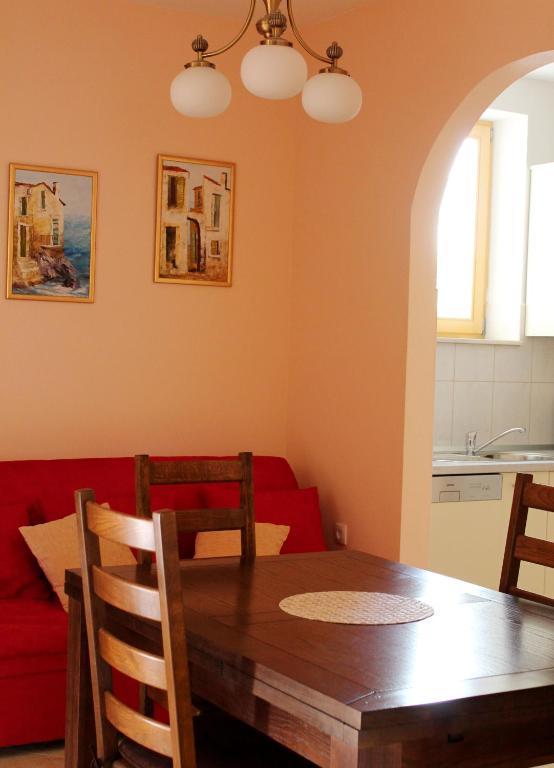 a dining room with a table and a red couch at Apartments Beautiful Sandy Beach in Split
