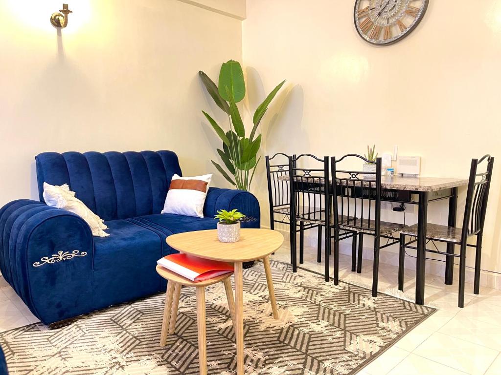 ein Wohnzimmer mit einem blauen Sofa und einem Tisch in der Unterkunft Cosy and spacious apartment in Meru in Meru