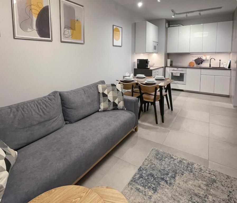 a living room and kitchen with a couch and a table at Apartament Cudovny in Kudowa-Zdrój