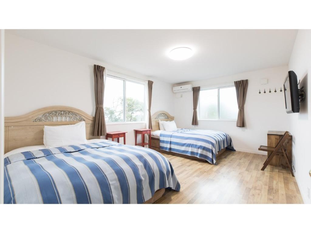 1 dormitorio con 2 camas y 2 ventanas en TEA TREES - Vacation STAY 86532v en Tateyama
