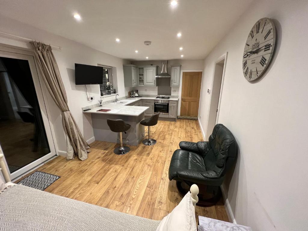 a kitchen and living room with a clock on the wall at Sandscroft Annex 5A in Broadway