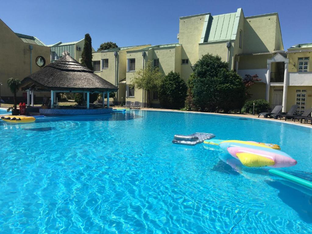 a large swimming pool with a raft and a boat in it at Helena Stúdió Apartman in Siófok