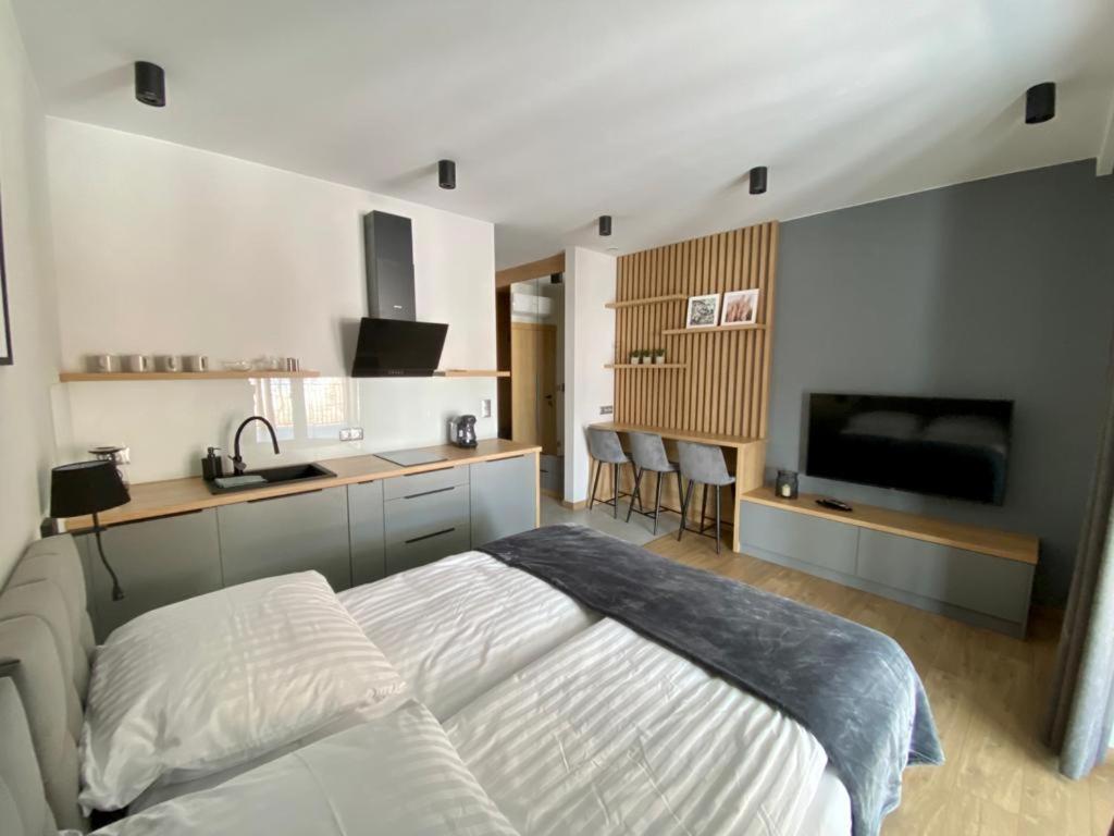 um quarto com uma cama branca e uma cozinha em Apartamenty WIERCHY em Klikuszowa