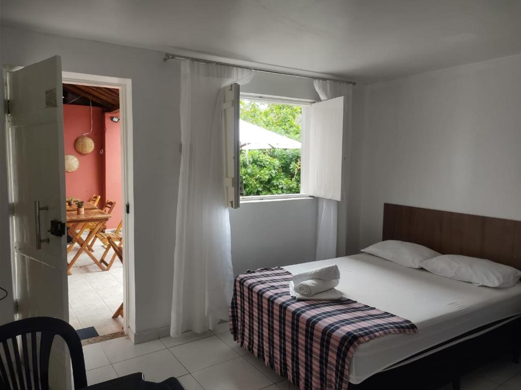 a bedroom with a bed and a window and a table at Pousada Maria Bonita - Piranhas, Alagoas. in Piranhas