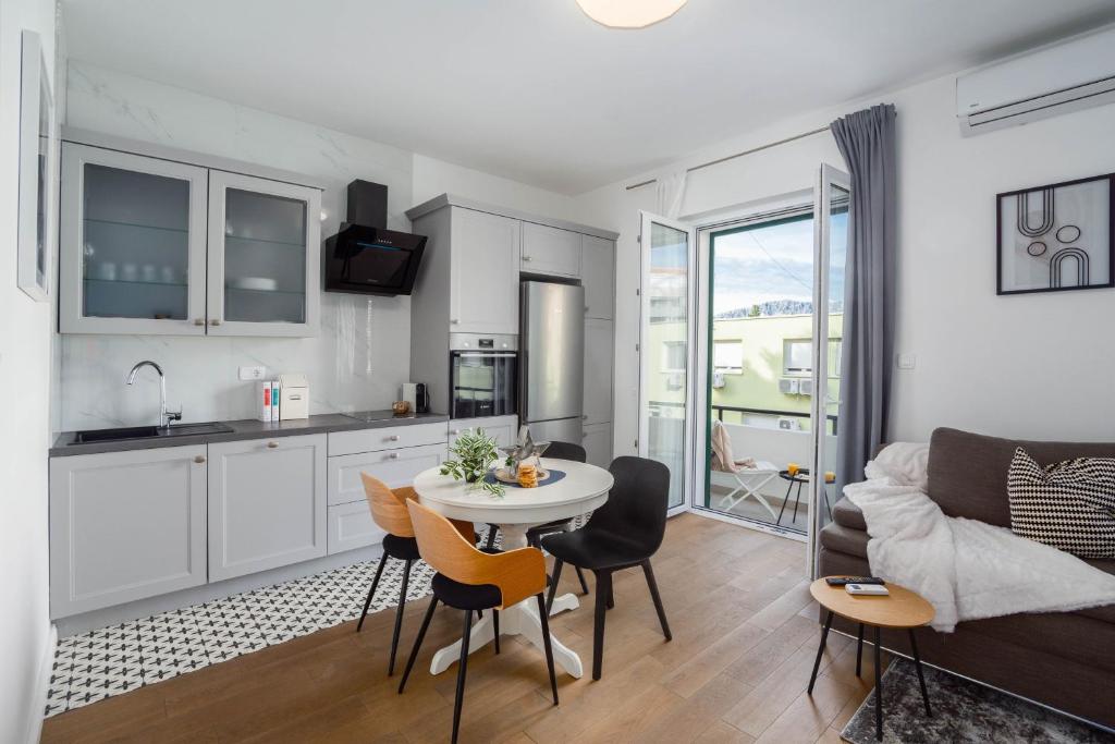a kitchen and a living room with a table and chairs at Finn Luxury Suites in Split