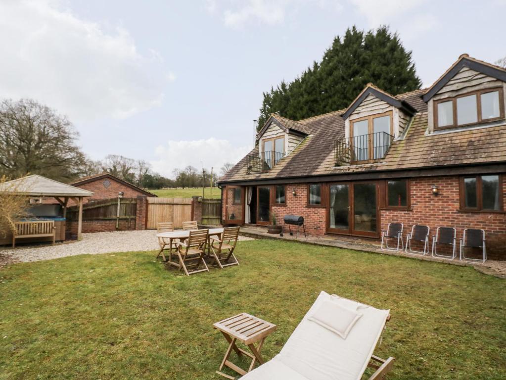 a house with a yard with chairs and a table at Meadowfall at Shatterford Lakes in Bewdley
