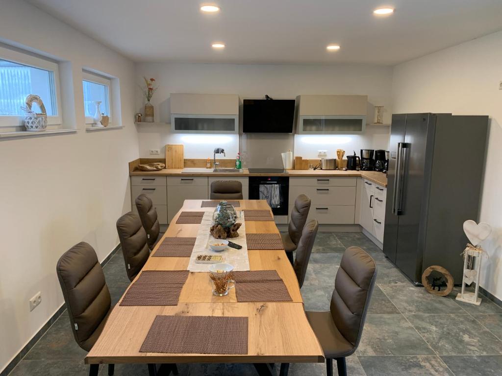a kitchen with a long wooden table and chairs at Haus Benz für 8 Personen - 4 Zimmer m. Dusche Vollausstattung 1km v. Wittenberge Baustelle A14 Parkplätze Grill Gemeinschaftsküche in Eickerhöfe