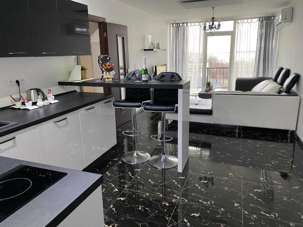 a kitchen with black and white counters and a counter top at Apartmán Bling s vírivkou Zemplínska Šírava in Kaluža