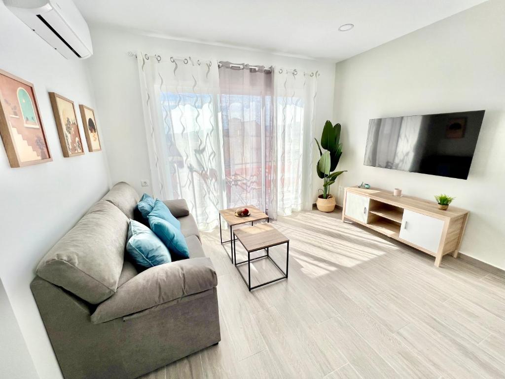 uma sala de estar com um sofá e uma televisão de ecrã plano em PISO EN EL CENTRO DE VELEZ MALAGA em Vélez-Málaga