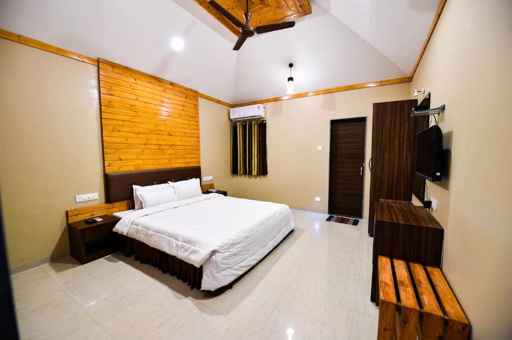 a bedroom with a bed and a television in it at The Kanila Resort in Karjat