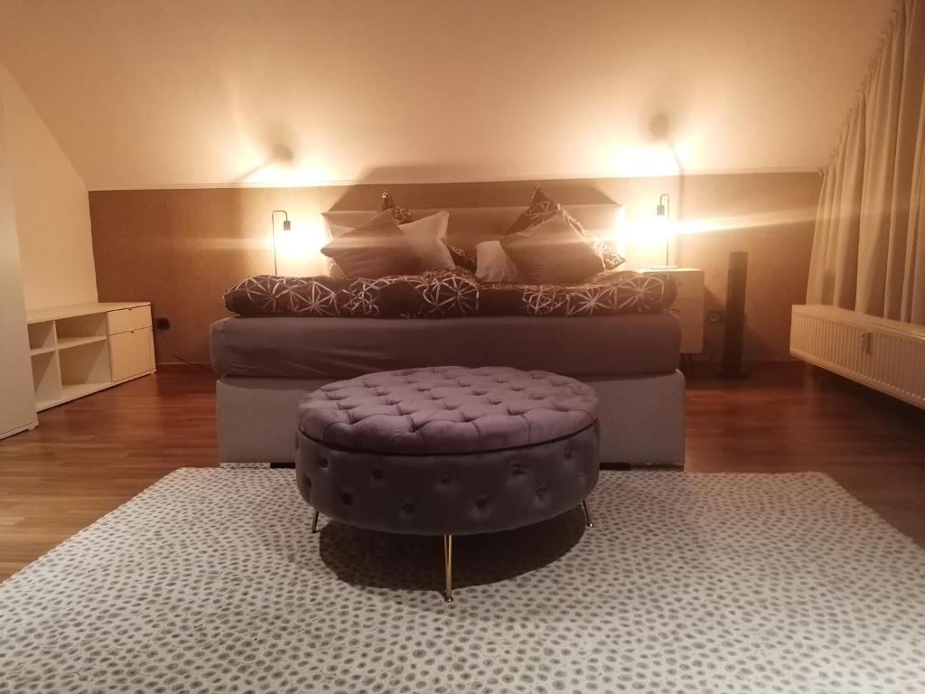 a living room with a bed and a ottoman at Ferienwohnung S+F Bokermann in Hörstel