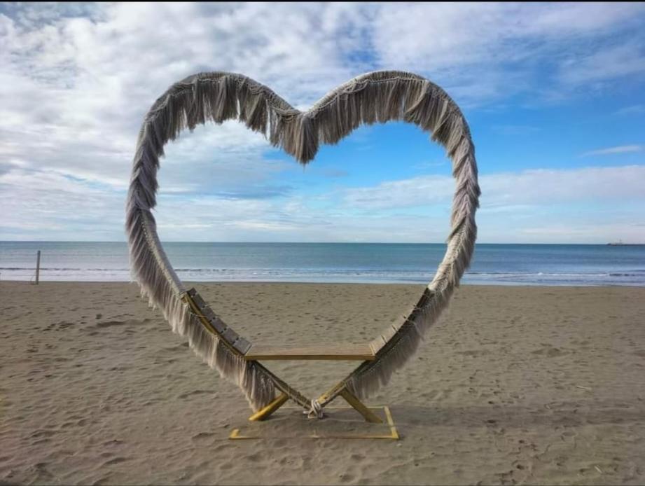 - une chaise de plage en forme de cœur sur la plage dans l'établissement luka apartament, à Shëngjin