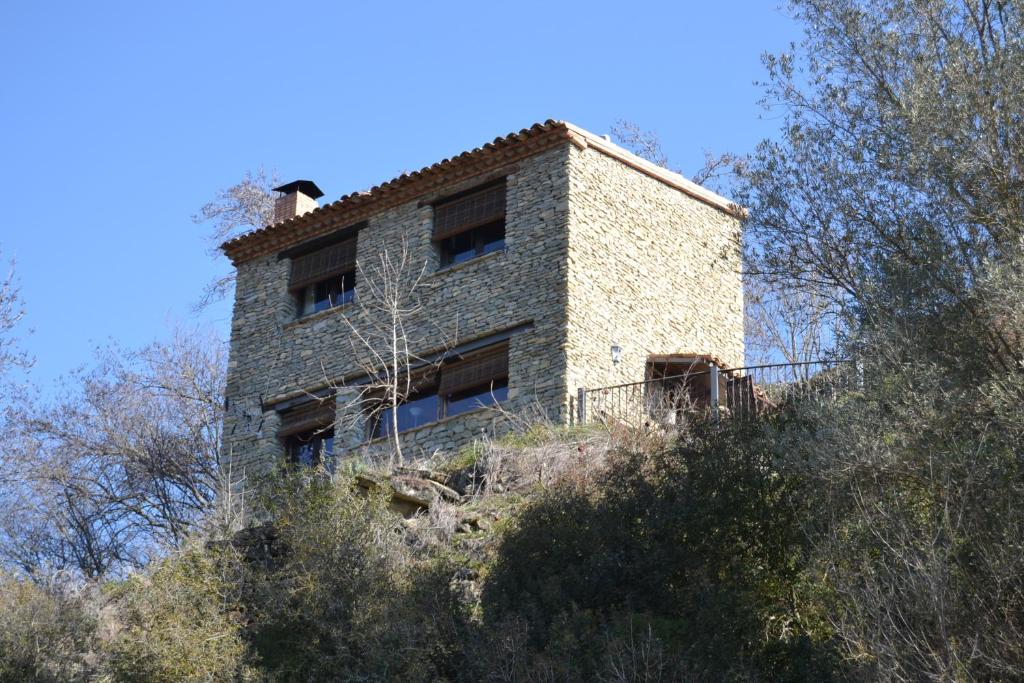 a building on top of a hill with trees at Casa JUNIA in La Baronia de Sant Oisme