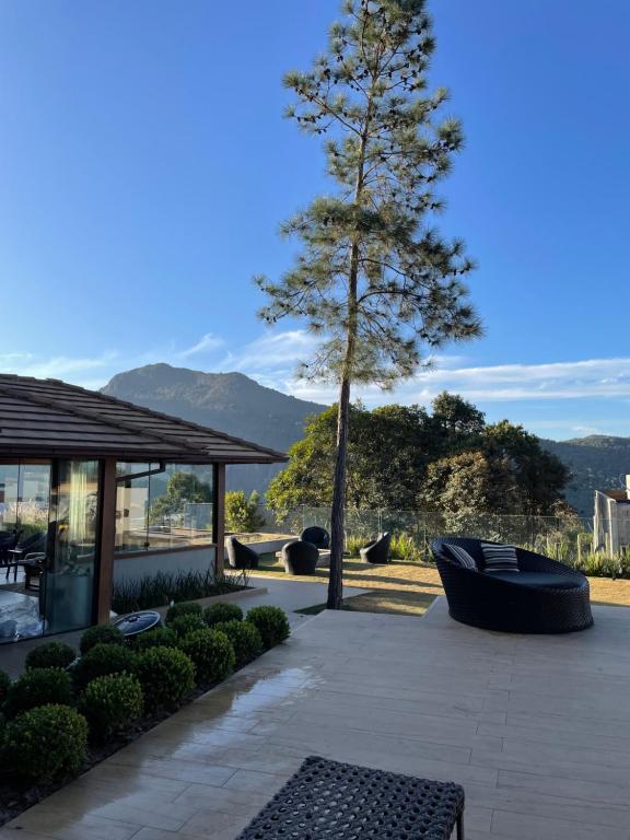 un patio con albero, tavolo e sedie di Casa 09 Monte Boa Vista - Refúgio com Piscina Privativa, Sauna e Vista das Montanhas a Teresópolis