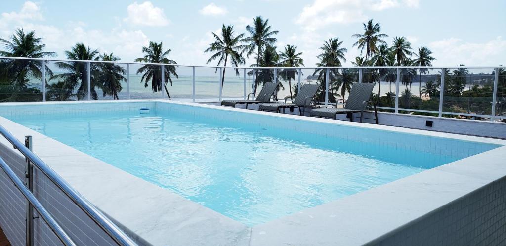 a swimming pool on top of a building with the ocean at Flat beira mar do Cabo Branco in João Pessoa