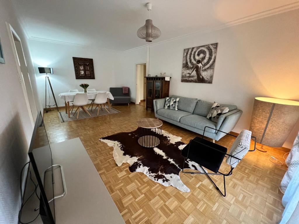 salon z kanapą i stołem w obiekcie Agréable appartement près du lac w mieście Versoix