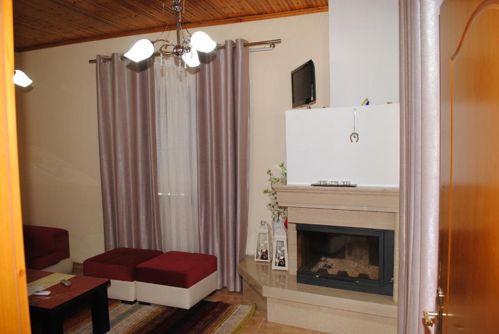 a living room with a fireplace and a red stool at George's Apartment in Gjirokastër