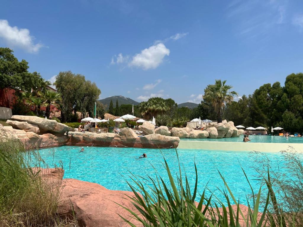 uma grande piscina com pessoas na água em AZUR APPARTEMENT (SEA VIEW) LES RESTANQUES DE ST-TROPEZ1131 em Grimaud