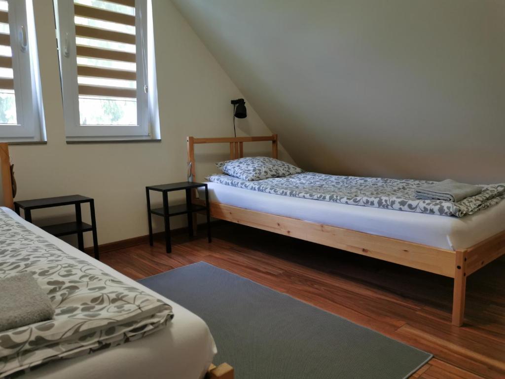 a bedroom with two beds and two windows at Przy Przystani in Stegna