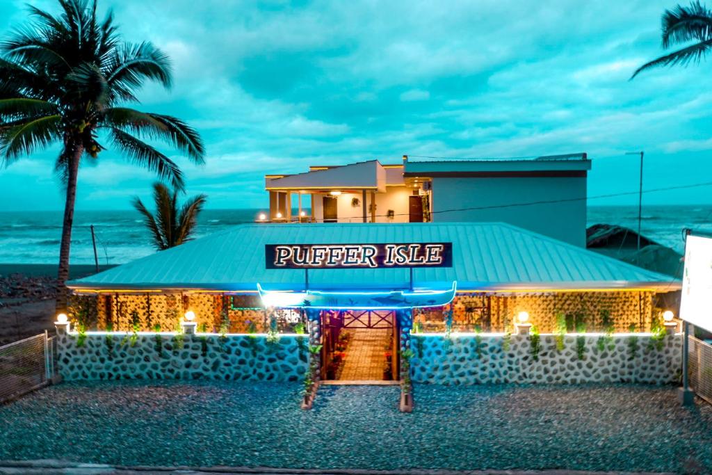 ein Gebäude am Strand mit einem lila Kussschild darauf in der Unterkunft Puffer Isle Resort in Dingalan