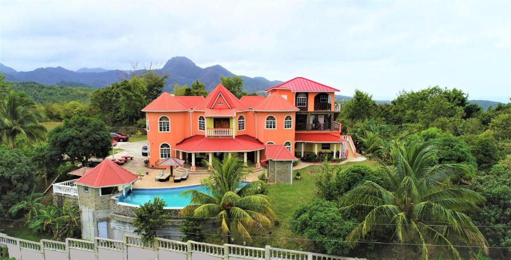 ein großes orangefarbenes Haus mit Pool davor in der Unterkunft Eden Crest Villa in Anse La Raye