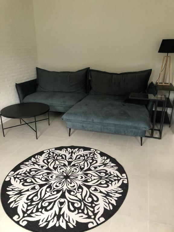 a living room with a couch and a black and white rug at Hof Busen Malibu in Mönchengladbach