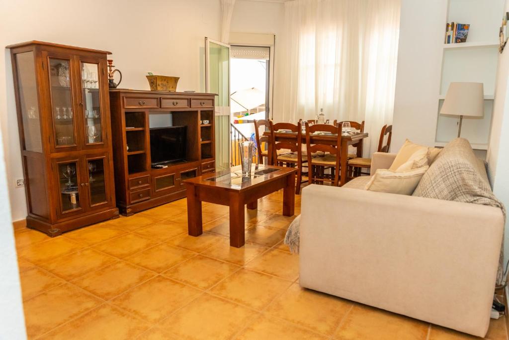 ein Wohnzimmer mit einem Sofa und einem Tisch in der Unterkunft Casa El Lance - Patio y Paseo Marítimo in Barbate