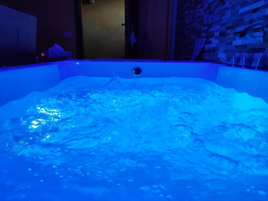 una vasca riempita di acqua blu in una stanza di COUNTRYSIDE SUITE a Ceprano