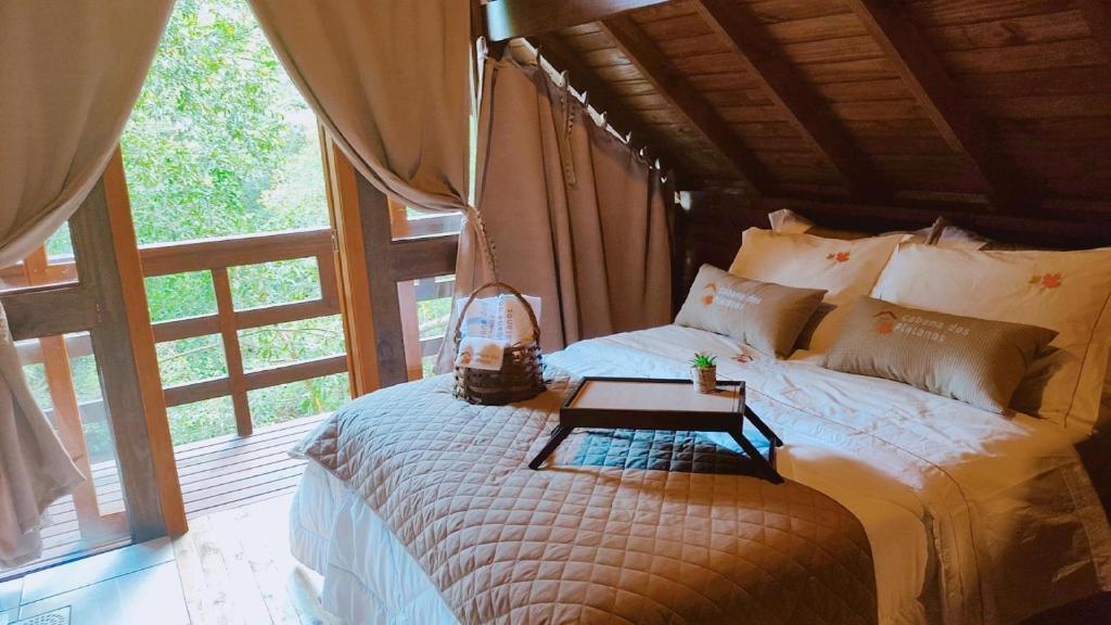 a bedroom with a bed with a table on it at Cabanas dos Plátanos in Gramado