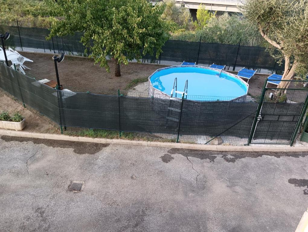 a fence around a swimming pool in a yard at La casina fra gli olivi in Massarosa