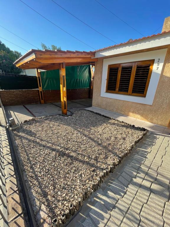 a house with a wooden roof and a patio at Casa céntrica en calle CB 297 in Villa Carlos Paz
