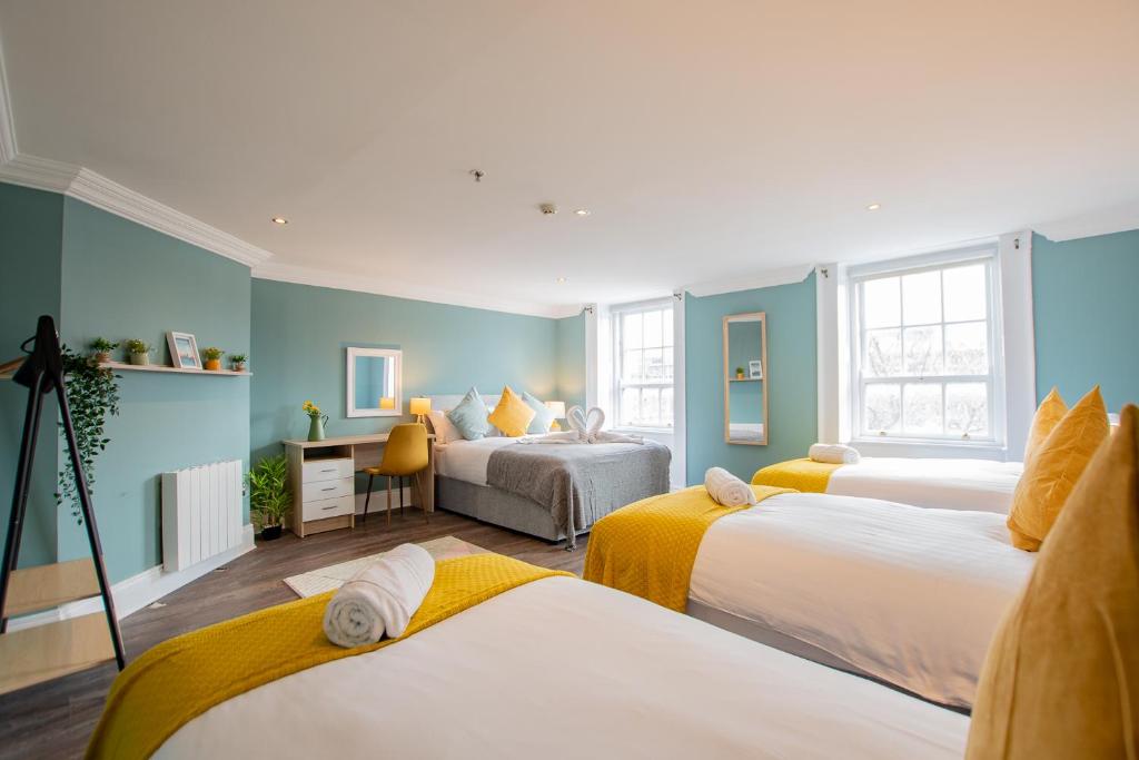 two beds in a room with blue walls at The Yellow Door by Shortstays in Dublin