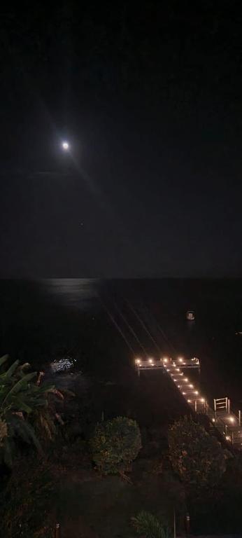 a view of the beach at night with a moon at Superbe appartement vue mer - résidence de standing in Schœlcher