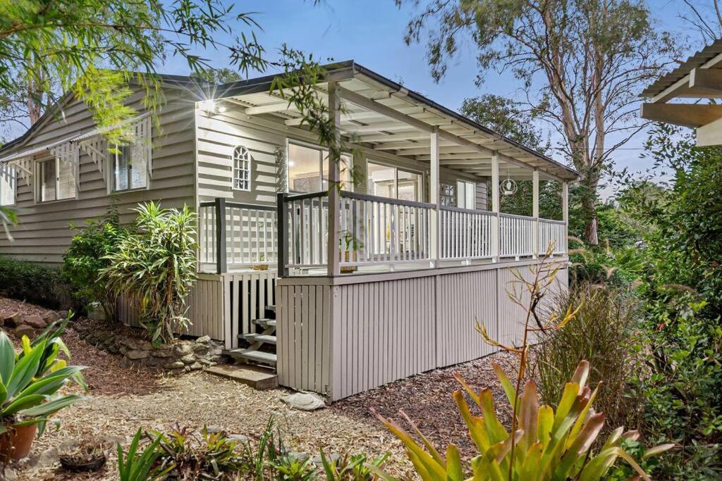 a small house with a porch and a balcony at Jardee Chateau Guest House in Conondale