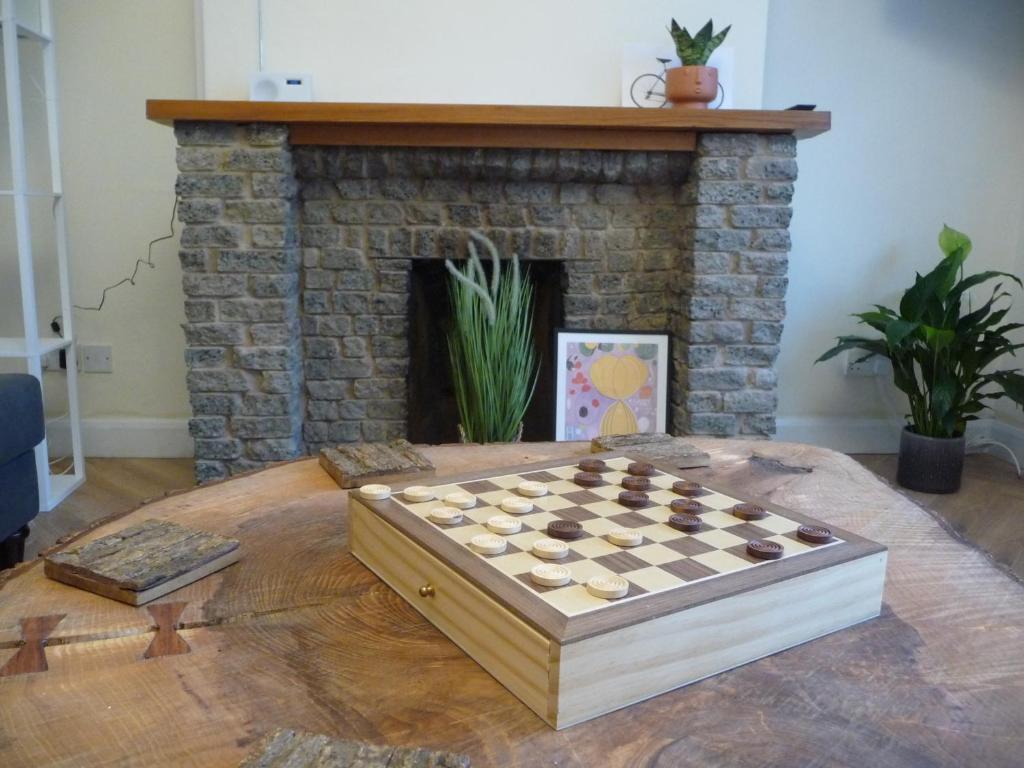 a chess board on a table in front of a fireplace at Bright spacious home, enclosed garden & parking in Hindlip