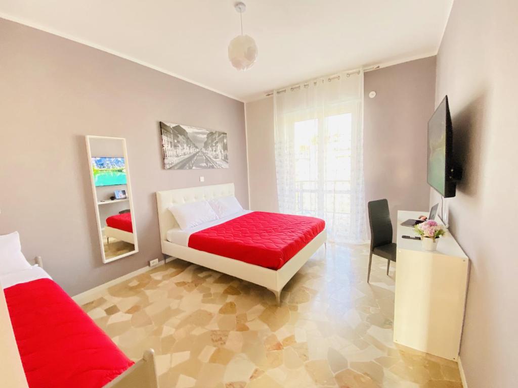 una camera con letto rosso e televisore di Milano relax family house a Brugherio