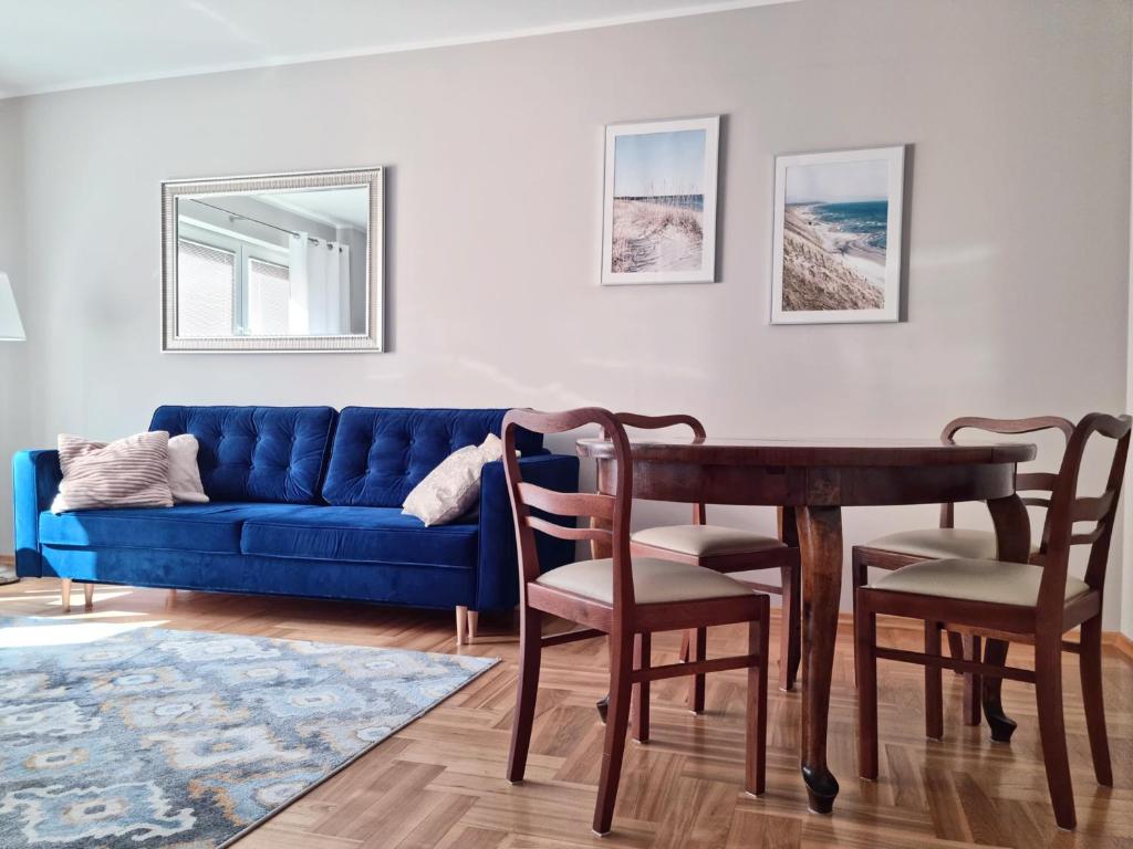 salon z niebieską kanapą i stołem w obiekcie CLASSY APARTMENTS - Gdynia - Słoneczny w mieście Gdynia