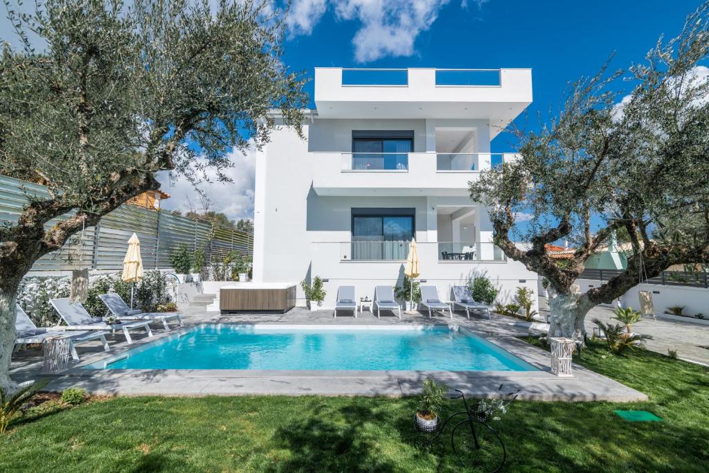 a villa with a swimming pool in front of a house at Royal View Villa - Private Pool & Hot Tub in Zakynthos Town