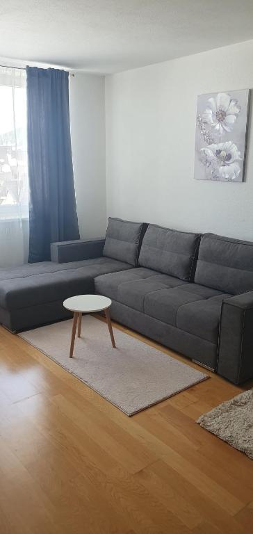 a living room with a black couch and a table at Studio Apartman Maša Kupres in Kupres