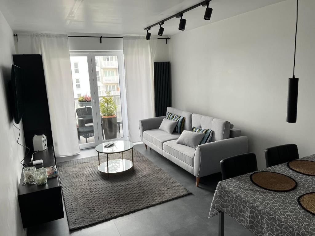 salon z kanapą i stołem w obiekcie Apartament Bażantów 26 w mieście Katowice