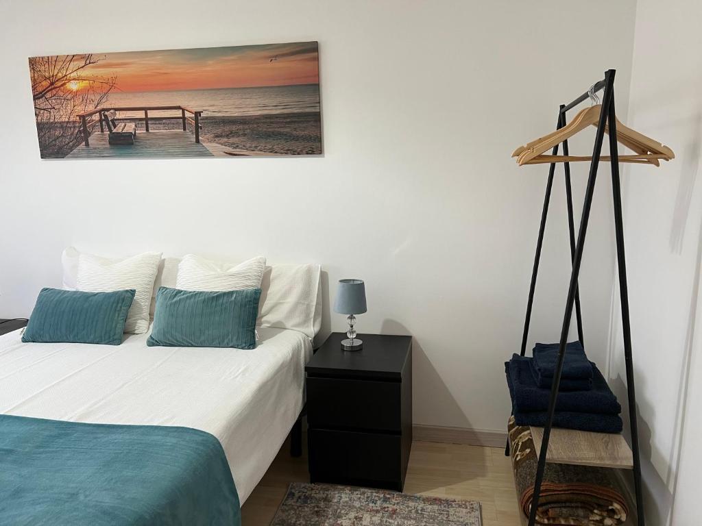 a bedroom with a bed and a desk with a picture on the wall at Confort Apartment 2 Bedrooms in Alhos Vedros