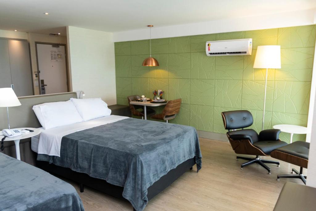 pokój hotelowy z łóżkiem, stołem i krzesłami w obiekcie 2906 Cobertura Beira Mar Av Boa Viagem w mieście Recife