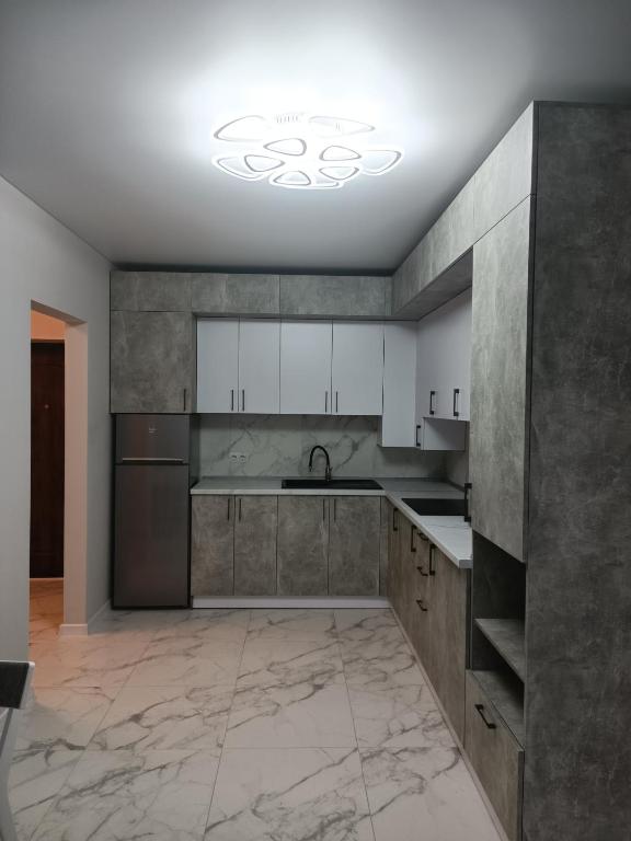 una cucina con armadi bianchi e pavimento in marmo di Apartments Domovik Myru St. 11s/21 a Mukačevo